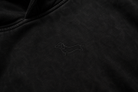 Detalle del bordado minimalista SALCHI CO en hoodie oversize negro acid wash