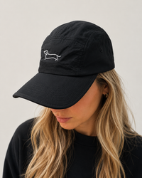 Mujer usando Origins Camper Cap negra impermeable SALCHI CO