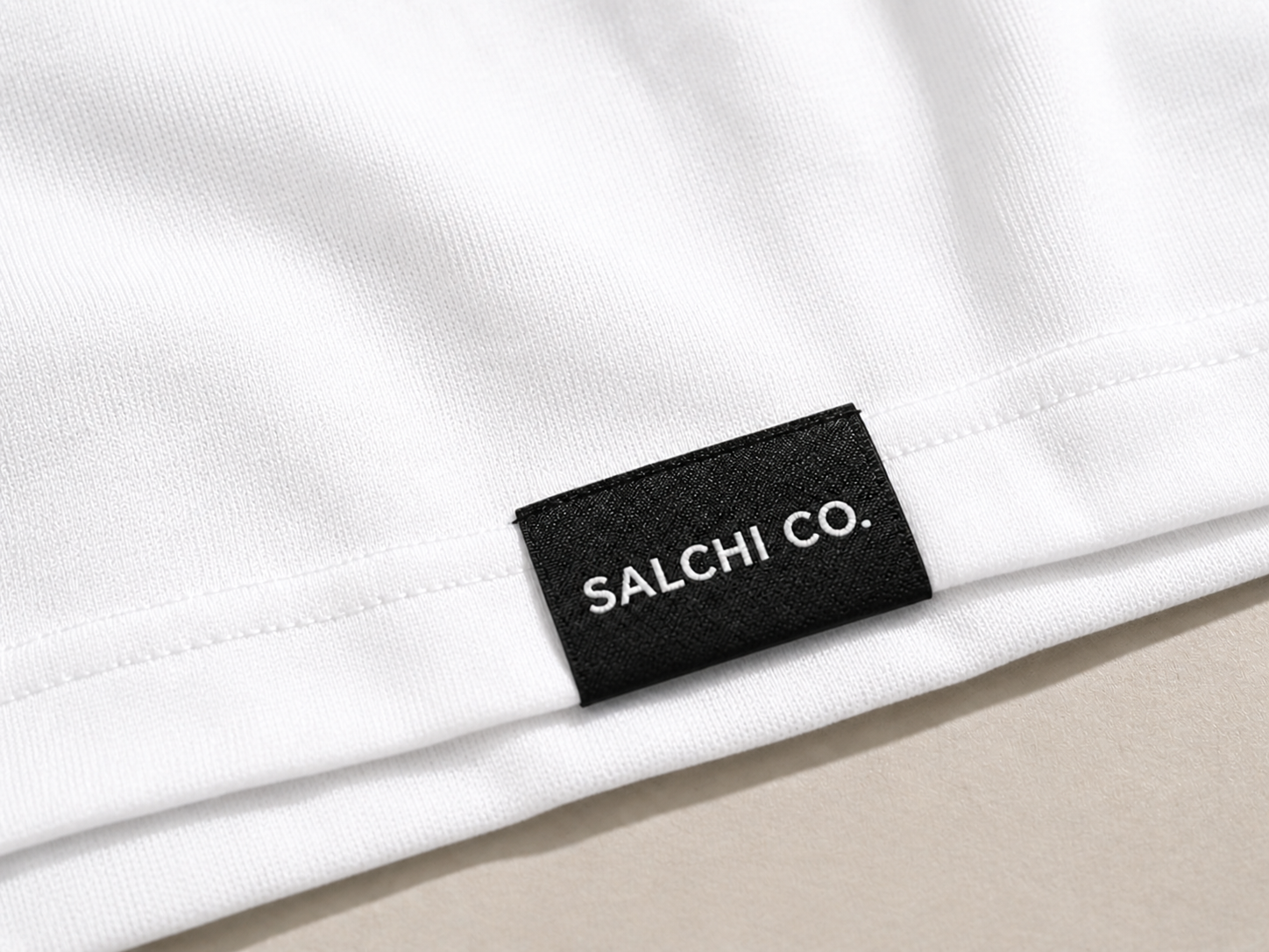 Etiqueta premium SALCHI CO en polera oversize blanca